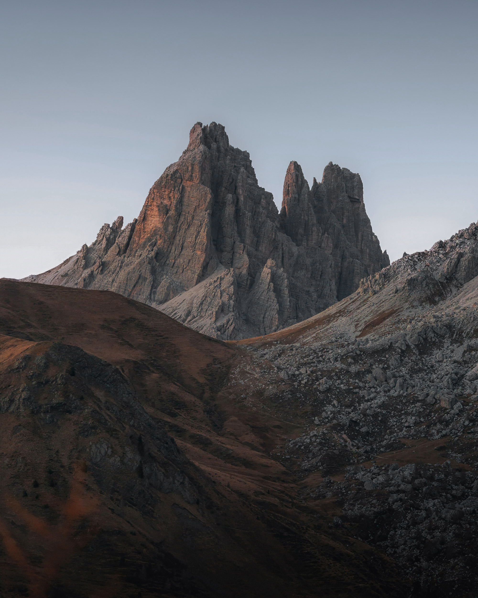 Sharp rocky spires under a clear sky during blue hour.