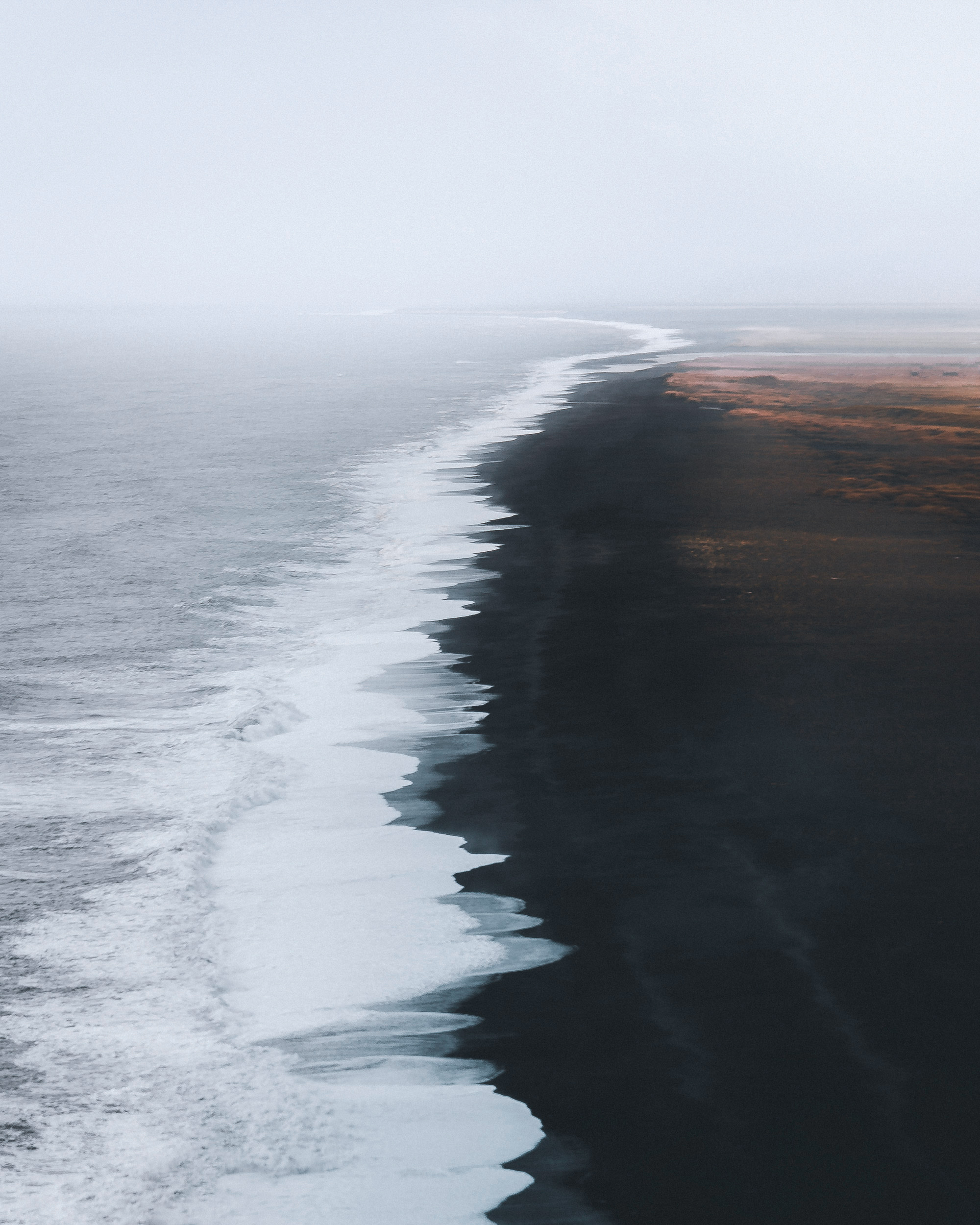 The image depicts a beach where waves are crashing onto the shore.