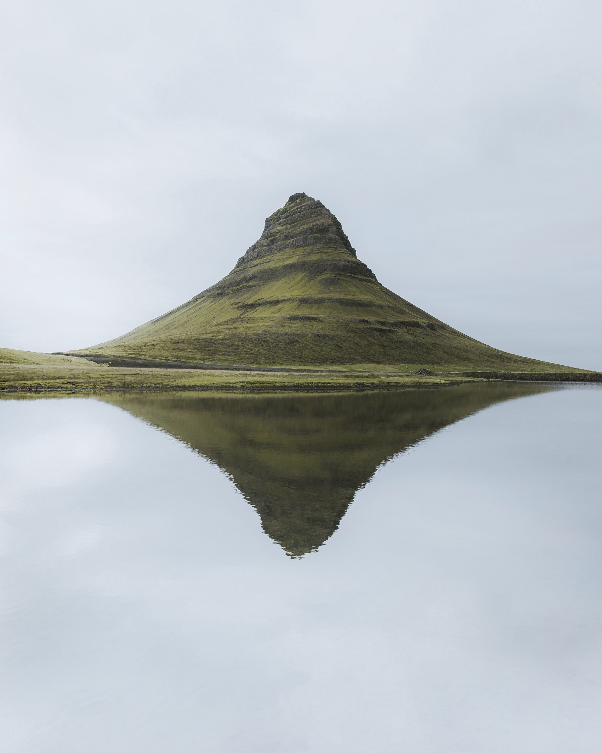 The image features a striking mountain rising from the water, creating a breathtaking natural scene.