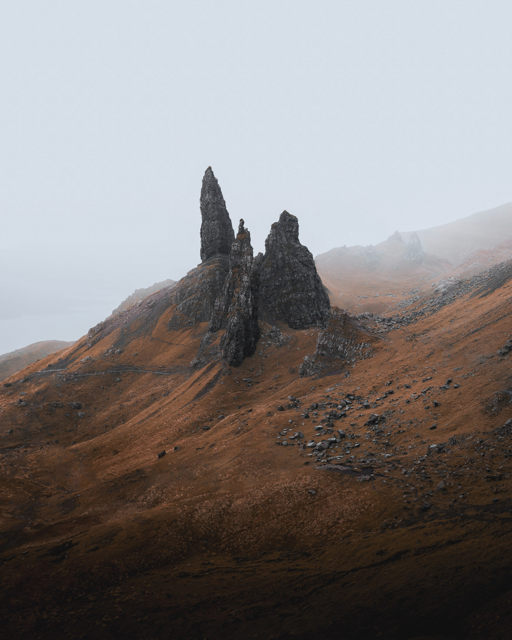 Ancient sentinels, sculpted by time, stand guard against a pale sky.