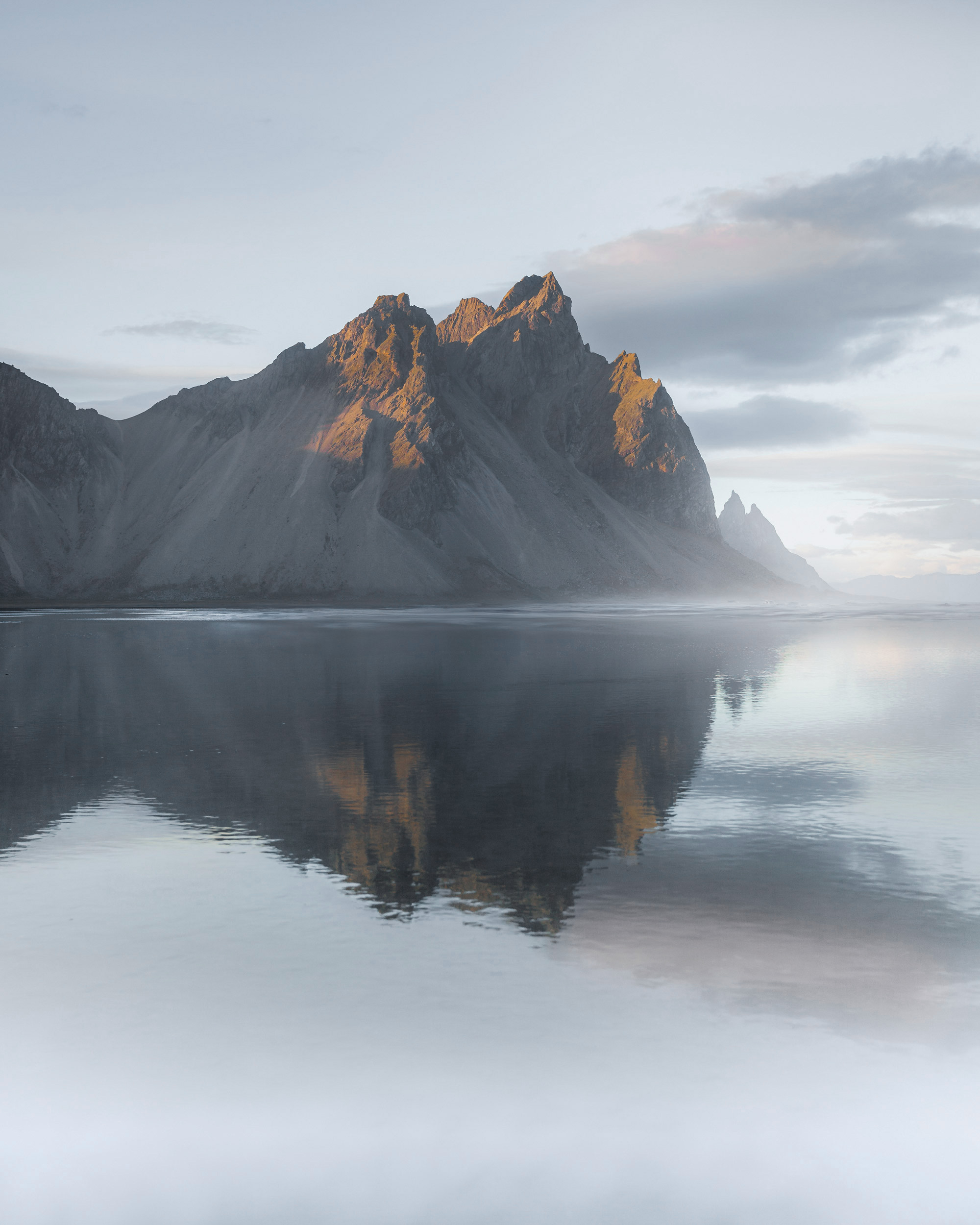 The mountains’ sharp silhouettes mirrored perfectly in the glassy water.